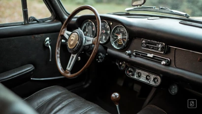 Het interieur van een klassieke Porsche 356, met origineel dashboard en stuurwiel, versleten leder.