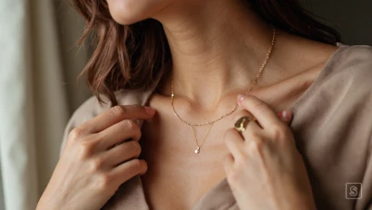 Vrouw doet gouden ketting om.