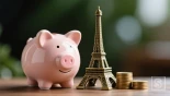 Een spaarvarken met een miniatuur Eiffeltoren ernaast.