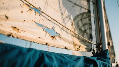 Close-up van een zeil met slijtage.