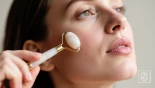Vrouw rolt een face roller over haar wangen