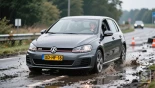 Bestuurder navigeert gladde weg, Volkswagen Golf.